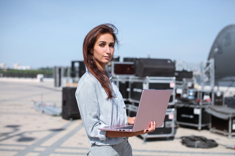 Festival planen - Frau mit Laptop in der Hand